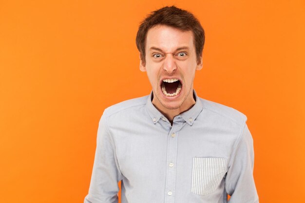 Portrait of man standing against orange background