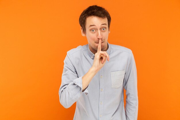 Portrait of man standing against orange background