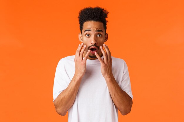 Portrait of man standing against orange background