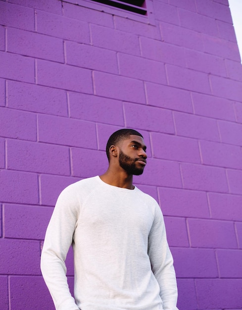 Portrait of man standing against purple wall