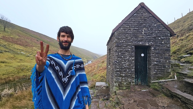 Portrait of man standing against smallest uk bothy