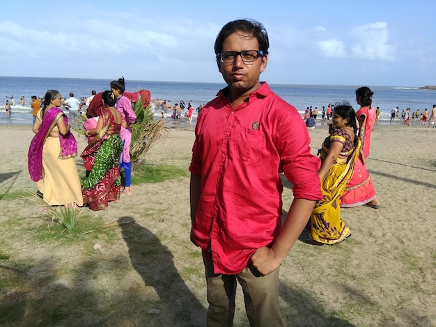 Portrait of man standing at beach against sky