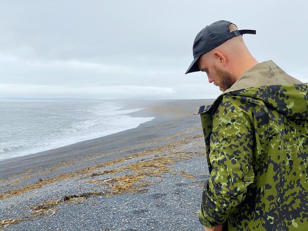 Photo portrait of man standing at beach against sky