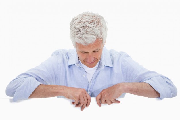 Photo portrait of a man standing behind blank panel