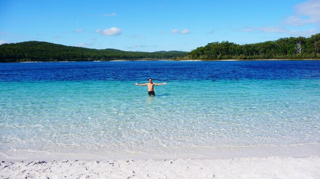 Photo portrait of man standing in blue sea against sky