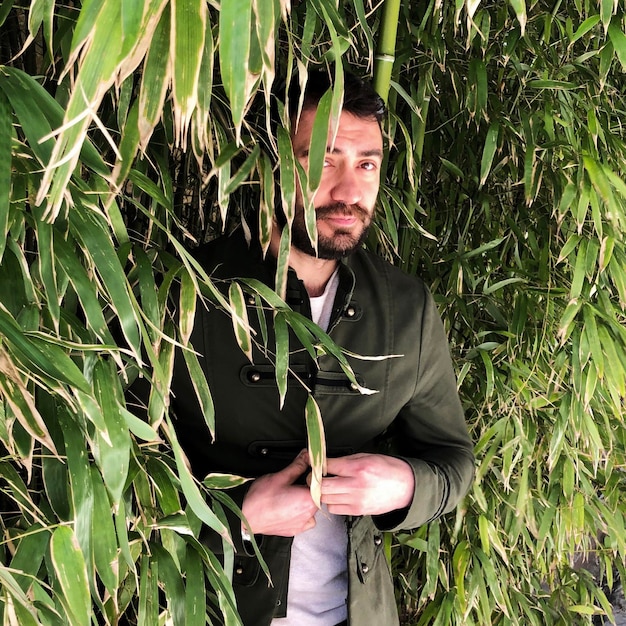 Photo portrait of man standing by plants