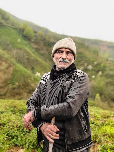 Photo portrait of man standing on field against mountain during winter