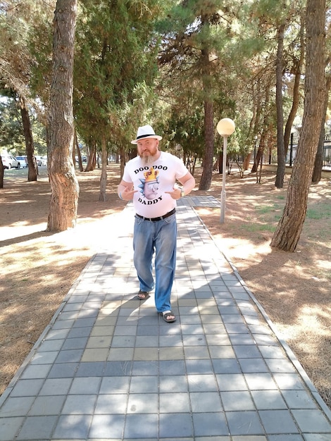 Photo portrait of man standing on footpath at park