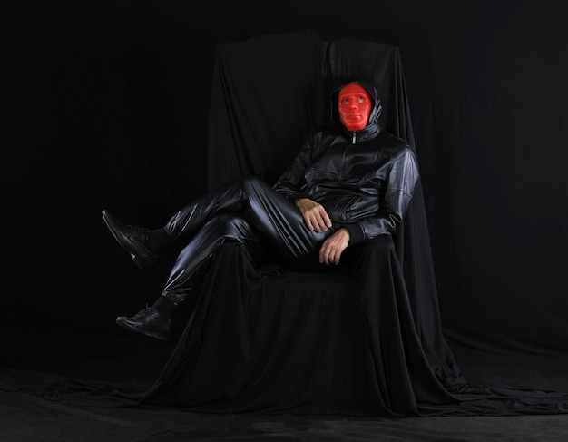 Photo portrait of a man in a strange theatrical mask on a black background