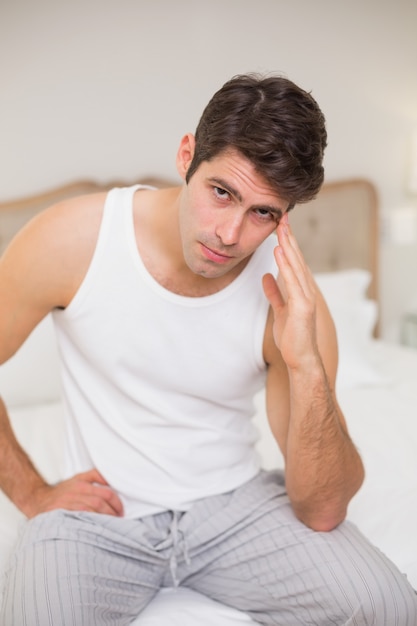 Portrait of man suffering from headache in bed