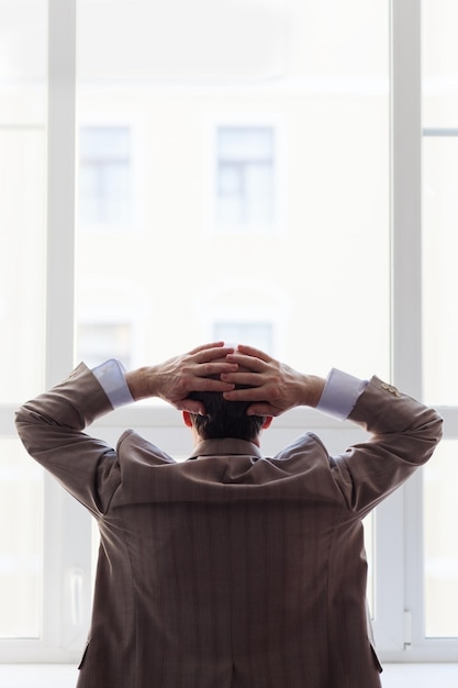 Portrait of a man in a suit by the window Snapshot from the back