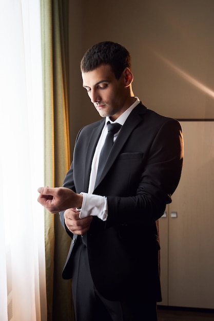 Portrait of a man in a suit and tie near the window