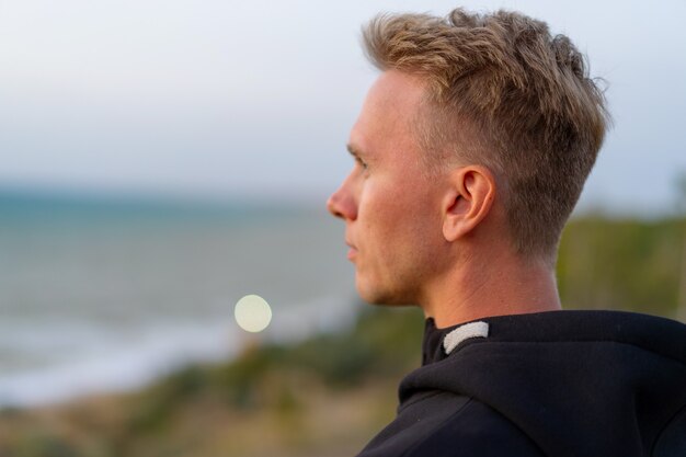 portrait of a man at sunset near sea, profile of a attractive face