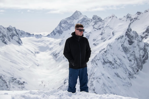 Portrait of a man on top of a snowy mountain.