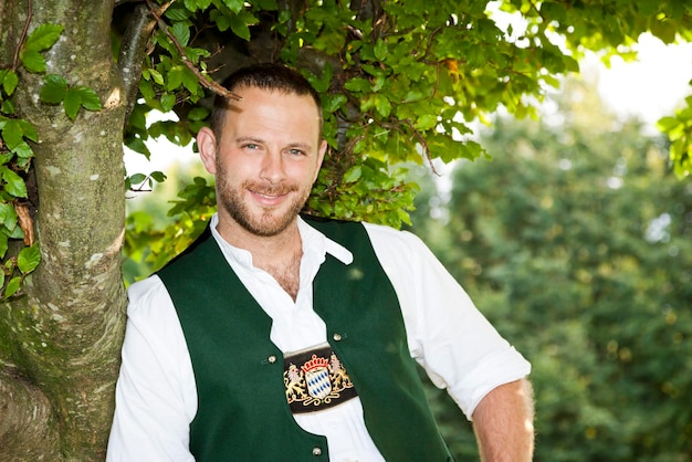 Photo portrait of man in traditional clothing standing by tree