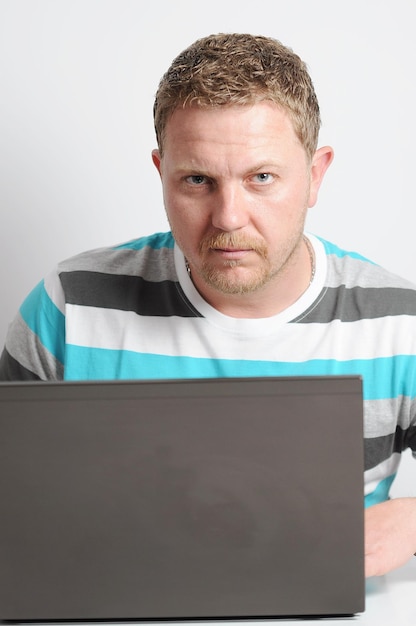 白い背景にラップトップを使用している男性の肖像画