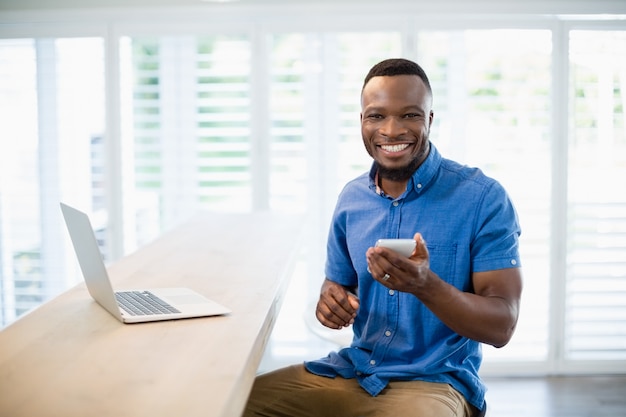 Portrait of man using mobile phone in living room