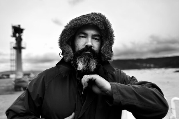 Photo portrait of man in warm clothing by water