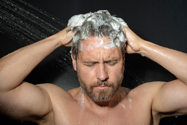 Портрет мужчины, моющего волосы шампунем, принимающего душ, моющего волосы шампунем