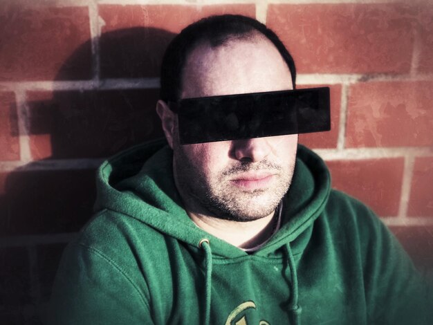 Photo portrait of man wearing 3-d glasses against brick wall