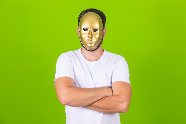 Portrait of man wearing golden mask on green background