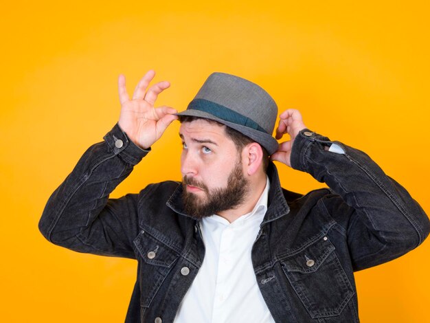 Portrait of man wearing hat against yellow background