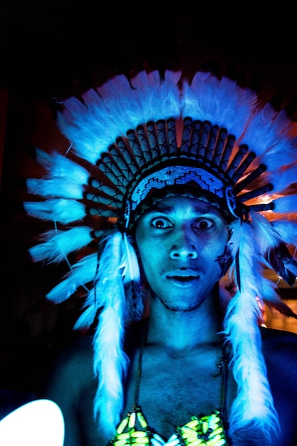 Photo portrait of man wearing headdress in darkroom