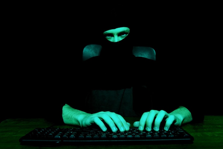 Photo portrait of man wearing mask tying on keyboard against black background