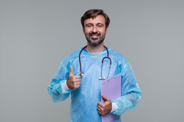 Photo portrait of man wearing medical gown and holding clipboard