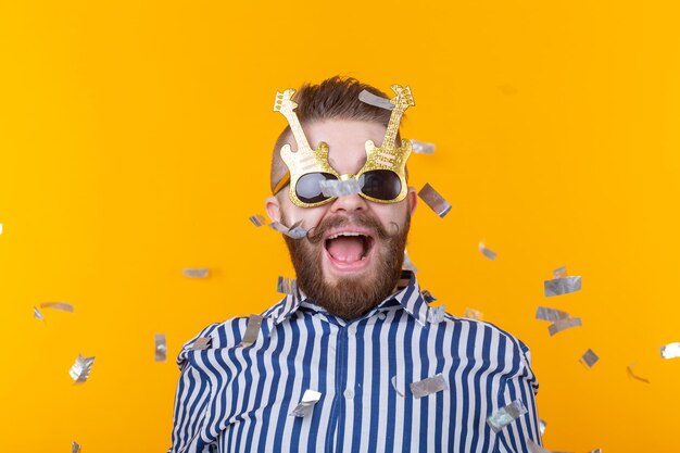 Portrait of man wearing sunglasses against yellow background