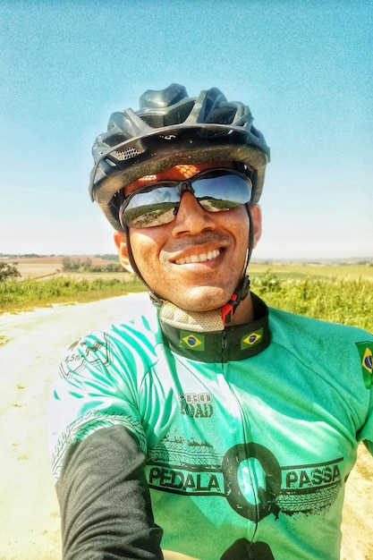 Photo portrait of man wearing sunglasses standing against clear sky ride a bicicle