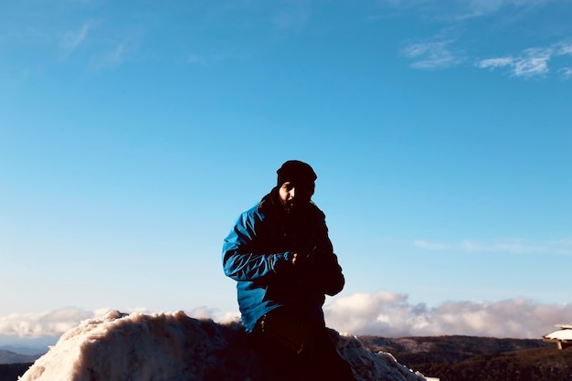 Foto ritratto di un uomo che indossa abiti caldi mentre è in piedi contro il cielo blu