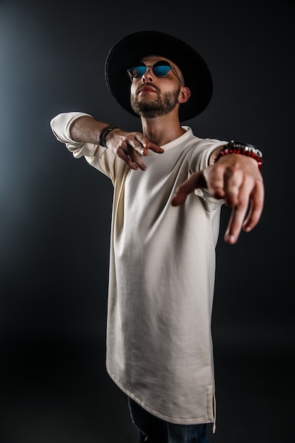 Photo portrait of a man in a widebrimmed hat and sunglasses on black