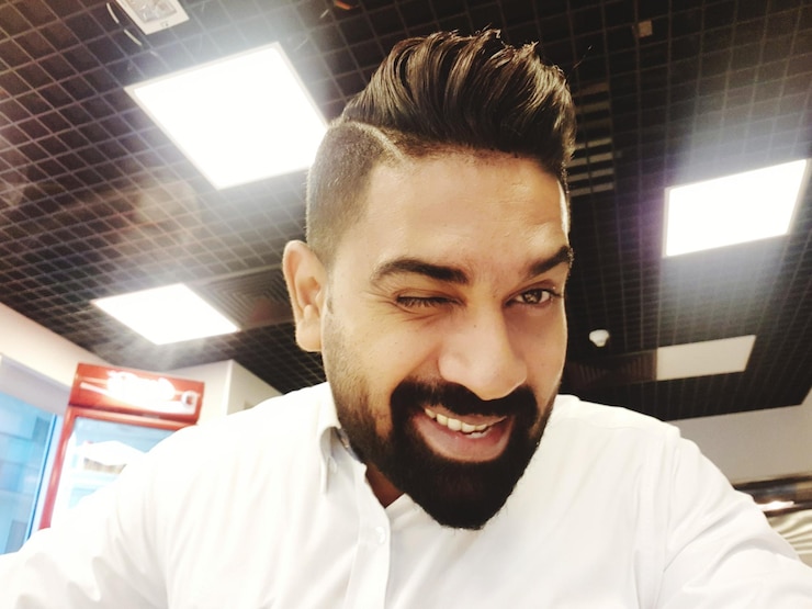 फोटो portrait of man winking against illuminated ceiling
