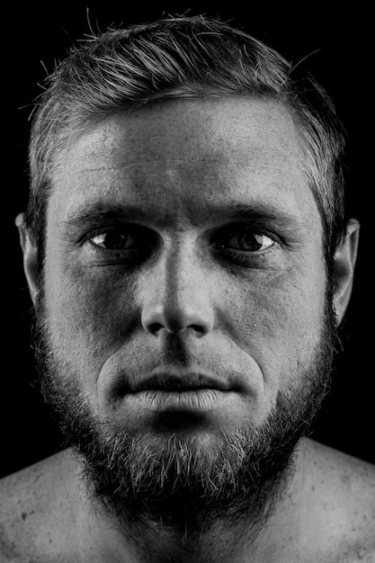 Portrait of a man with a beard on a black background.