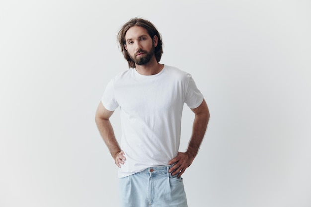 Portrait of a man with a black thick beard and long hair in a white Tshirt on a white isolated background emotion of sadness and longing