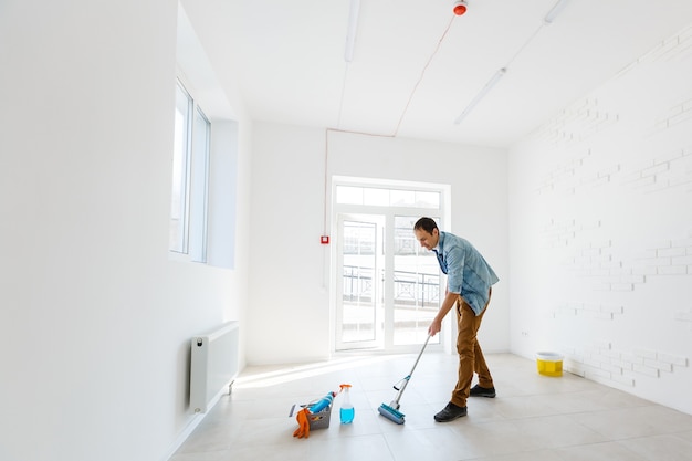 portrait of man with cleaning equipment cleaning the house