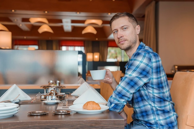 Portrait of man with coffee and breakfast in restaurant of luxury hotel