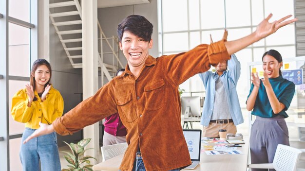 Photo portrait of man with colleagues clapping in background