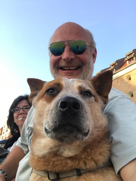 Photo portrait of man with dog by woman smoking cigarette