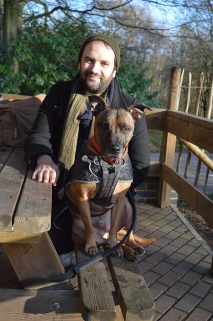 Photo portrait of man with dog on porch