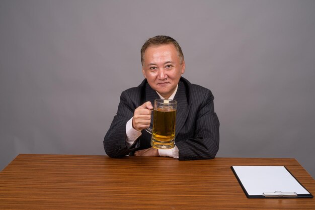 Portrait of a man with drink sitting on table