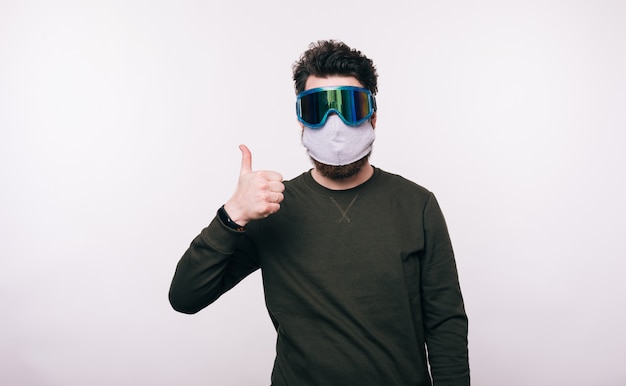 Portrait of man with facial mask showing thumbs up