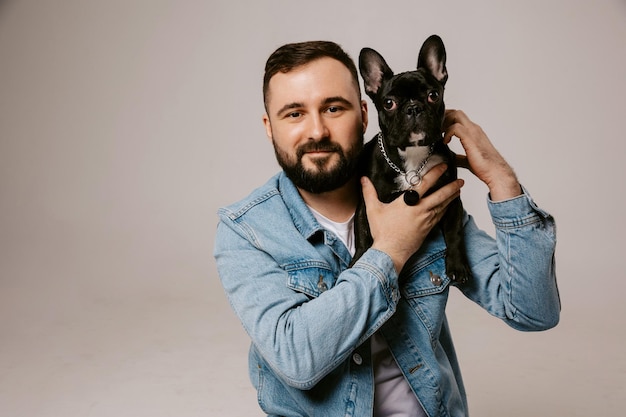 Ritratto di uomo con bulldog francese su sfondo bianco