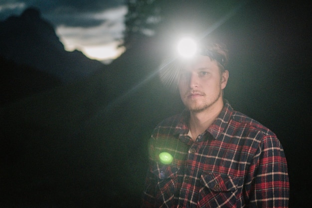 Foto ritratto di un uomo con apparecchiature di illuminazione illuminate di notte