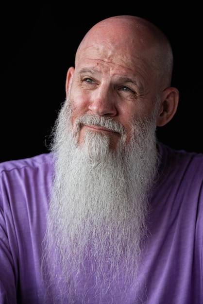 Portrait of man with long gray beard wearing purple tshirt closeup shot