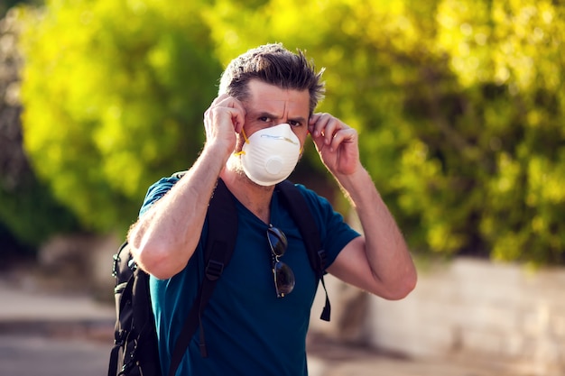 Un ritratto dell'uomo con la maschera di protezione medica all'aperto