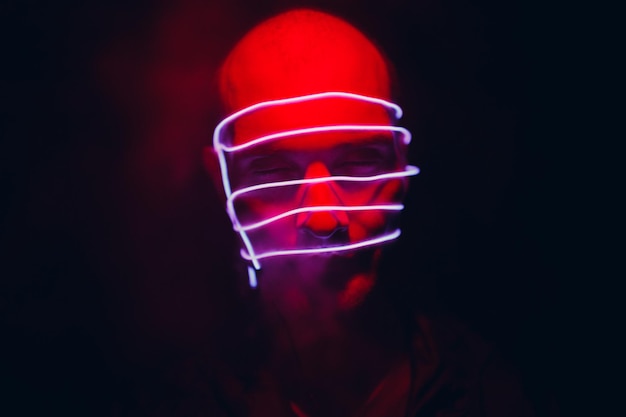 Ritratto di uomo con linee di bagliore al neon sul viso concetto cyberpunk e realtà virtuale