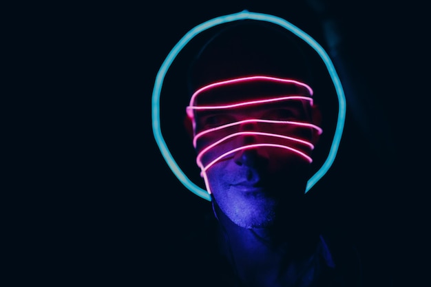 Portrait of man with neon glow lines on his face Concept cyberpunk and virtual reality