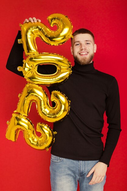 Portrait of a man with the numbers 2022 on a red background. the coming new year